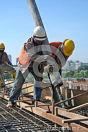 Construction Workers Using Concrete Hose from Concrete Pump Editorial Stock Photo